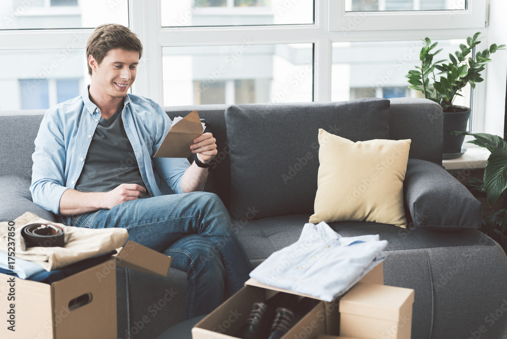 Smiling male looking at envelope Smiling male looking at envelope