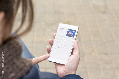 Woman using smart phone. Christmas calendar