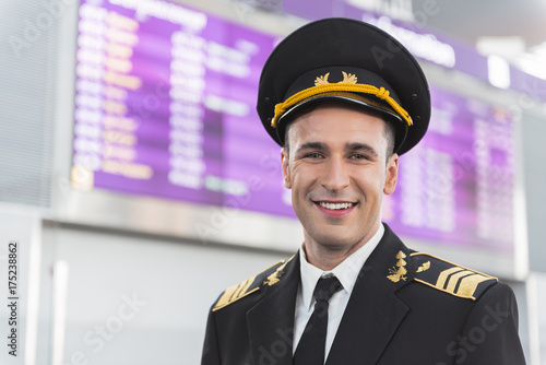 Happy smiling aviator glancing ahead in airport