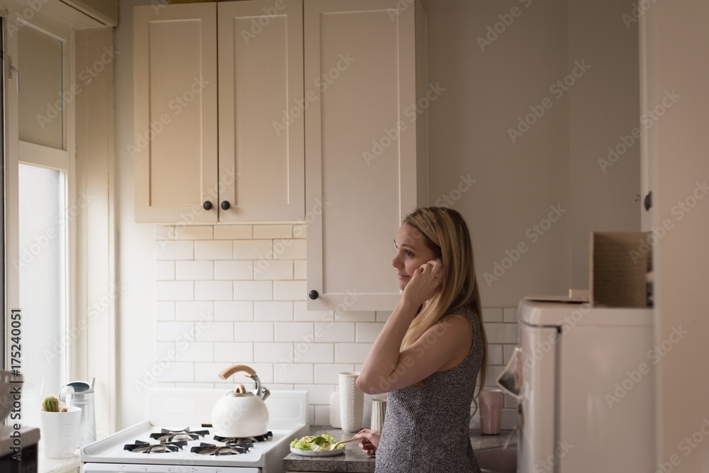 Side view of woman using phone in kitchen Side view of woman using phone in kitchen