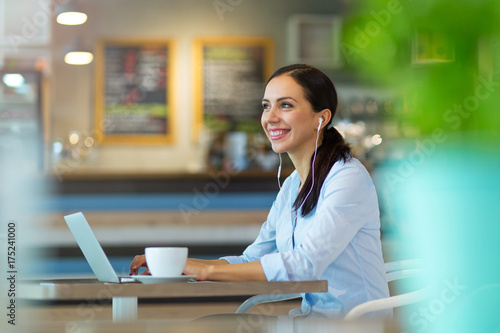 Woman using laptop in cafe 