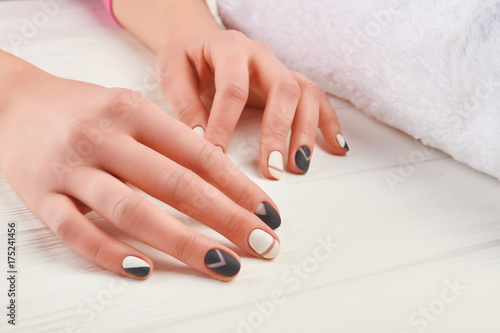 Girl hands with beautiful manicure. Female hands with fashion design nails in beauty salon. Black and white manicure art design.
