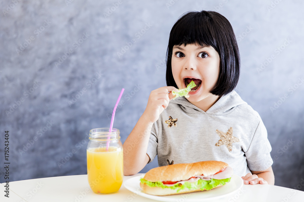 Cuttle black hair little girl having breakfast and eat lettuce Cuttle black hair little girl having breakfast and eat lettuce