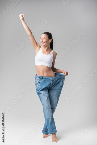 Glad thin young woman is satisfied with her figure photo