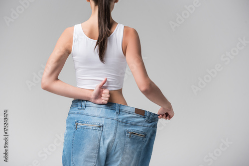 Thin young woman presenting result of diet