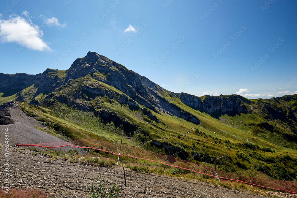 Beautiful green mountain landscape with bright blue sky. North Caucasus.