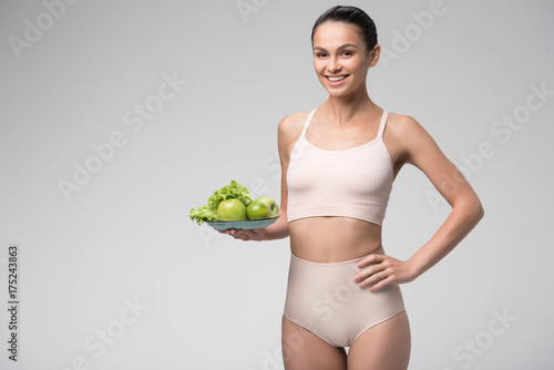 Joyful fit young woman holding fruits and vegetables © Yakobchuk Olena