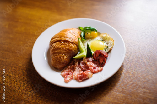 Fresh croissant with ham and salad