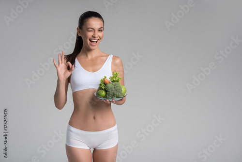 Cheerful thin girl eating only vegetables and fruits © Yakobchuk Olena