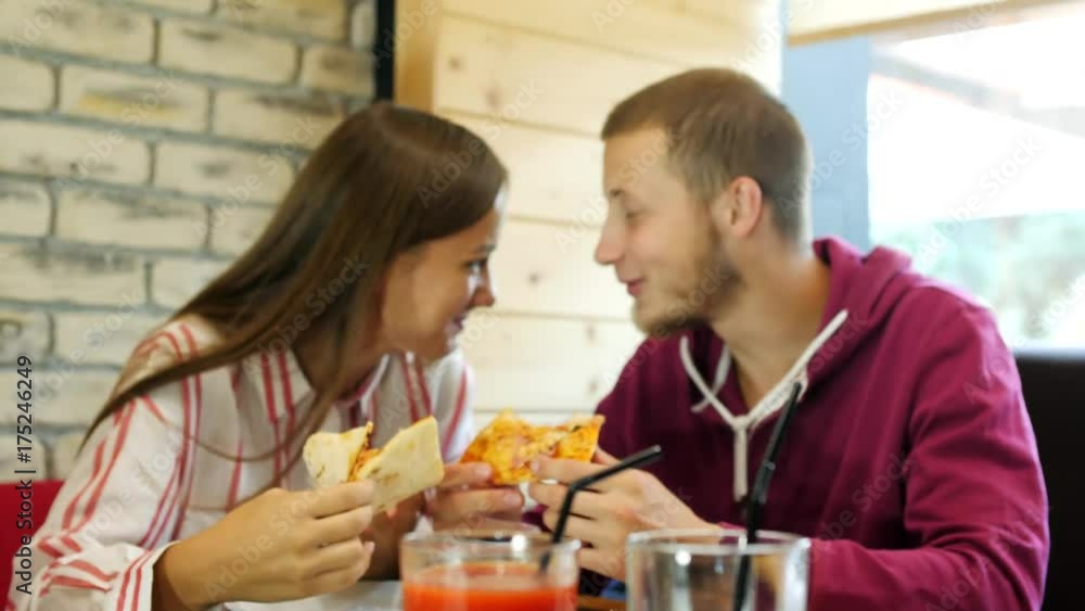 The guy and the girl were eating and talking on the background of juice.