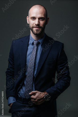 Handsome successful businessman in a dark suit against a dark background