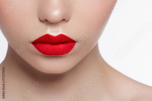 The macro photo of the closed female mouth. Chubby lips with red lipstick show a fashionable make-up and increase in lips. Cosmetology, Spa, cosmetics © evgeniyasht19