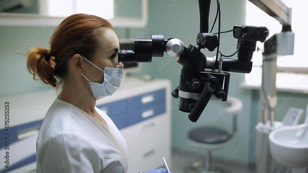 Female dentist with dental tools - microscope, mirror and probe treating patient teeth at dental clinic office. Medicine, dentistry and health care concept. Dental equipment Female dentist with dental tools - microscope, mirror and probe treating patient teeth at dental clinic office. Medicine, dentistry and health care concept. Dental equipment