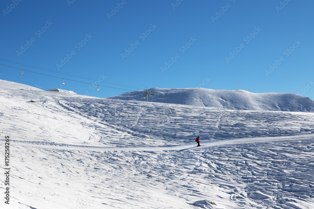 Skier downhill on ski slope at nice sun morning