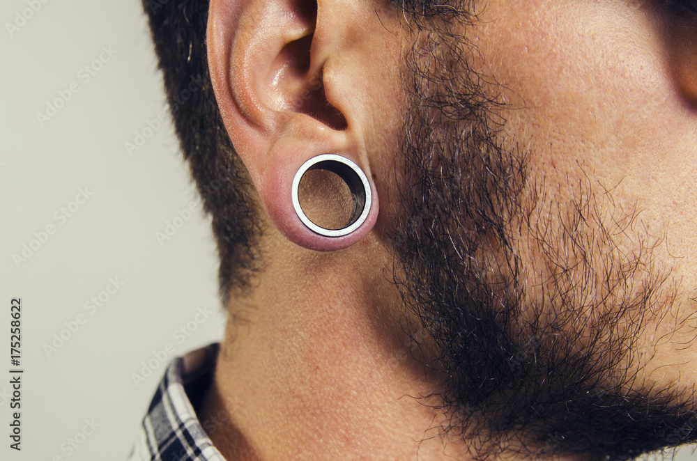 Closeup of hipster ear, with hole earring. Stock Photo | Adobe Stock