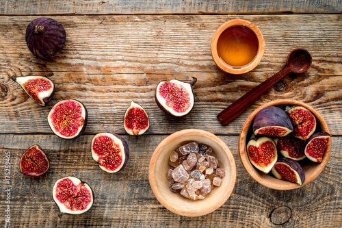 Fototapeta Naklejka Na Ścianę i Meble -  Make jam. Fresh blue figs in bowl, sugar and honey on wooden background top view