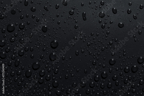 Closeup of black raindrops on dark surface, abstract background