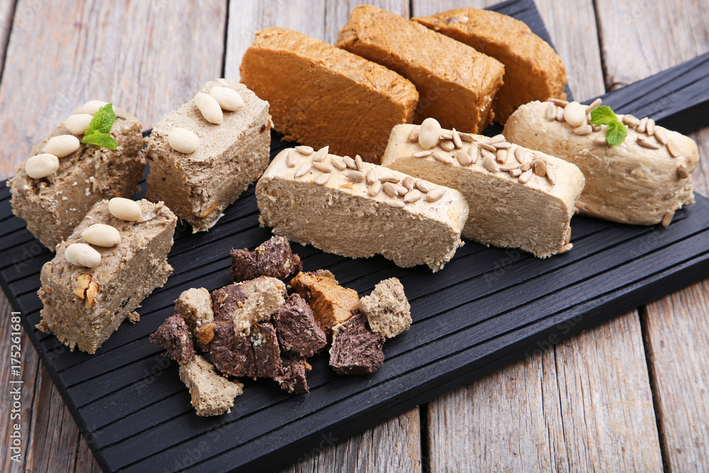 Fototapeta premium Tasty slices of halva on cutting board