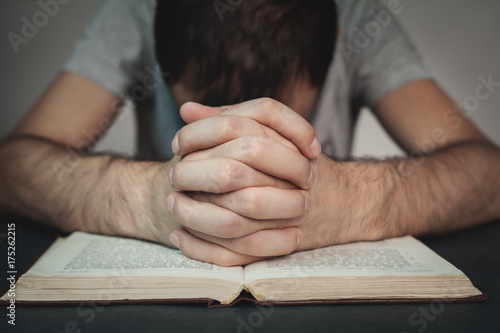Man praying with a bible.