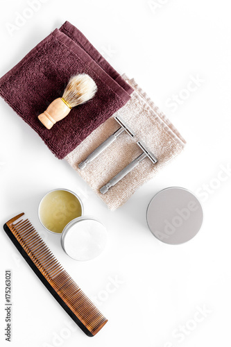 Workplace in barbershop. Razor, shaving brush, comb on white background top view