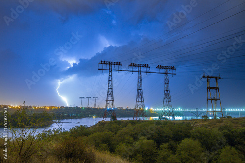 Lightning over the power line pylon towers at night