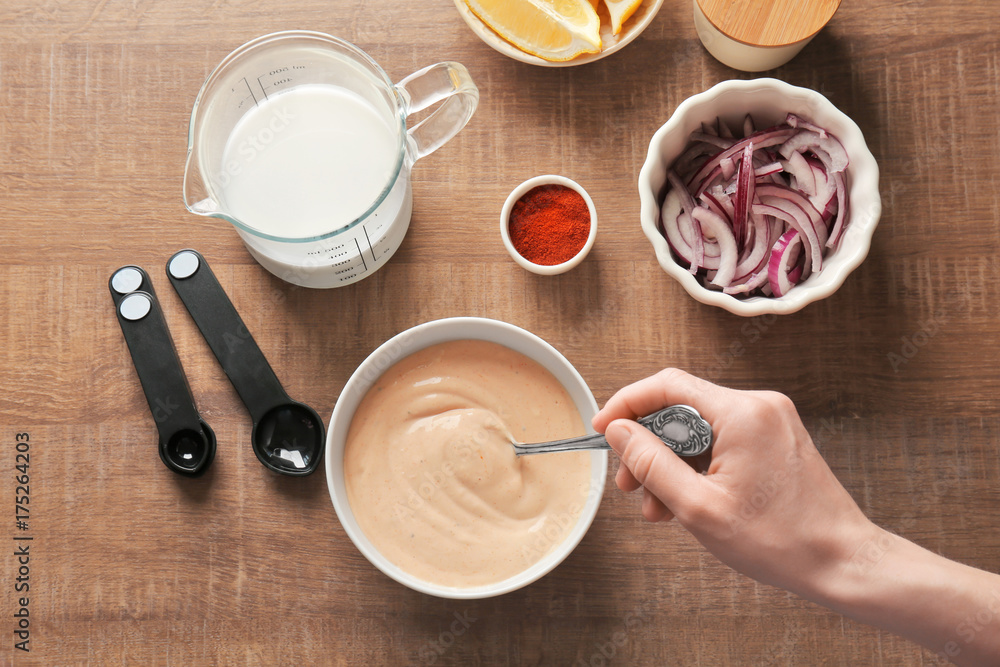 Woman preparing sauce for fish taco in kitchen Woman preparing sauce for fish taco in kitchen