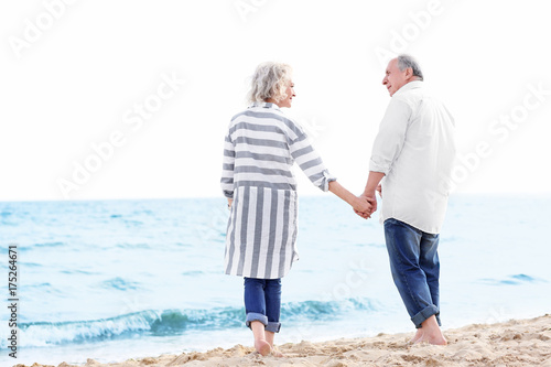 Happy senior couple walking at sea