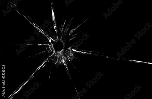 bullet hole in glass close up on black background