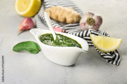 Gravy boat with chutney mint sauce on table