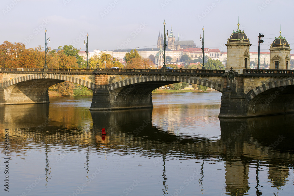 View of the Prague Castle and the bridge on the Vltava River in a misty autumn morning. Prague. Czech Republic .