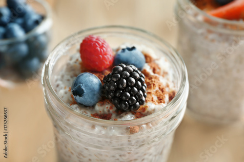 Jar of delicious chia seed pudding with berries on table  close up