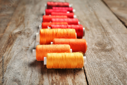 Color sewing threads on wooden background