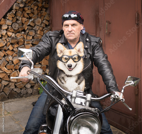 Photo of humor. The biker and his dog are sitting on a motorcycle. © veronika7833