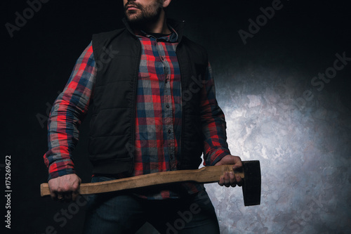 Confident axeman. Armed man with axe. Dangerous unrecognizable rural man on black background closeup, protection concept