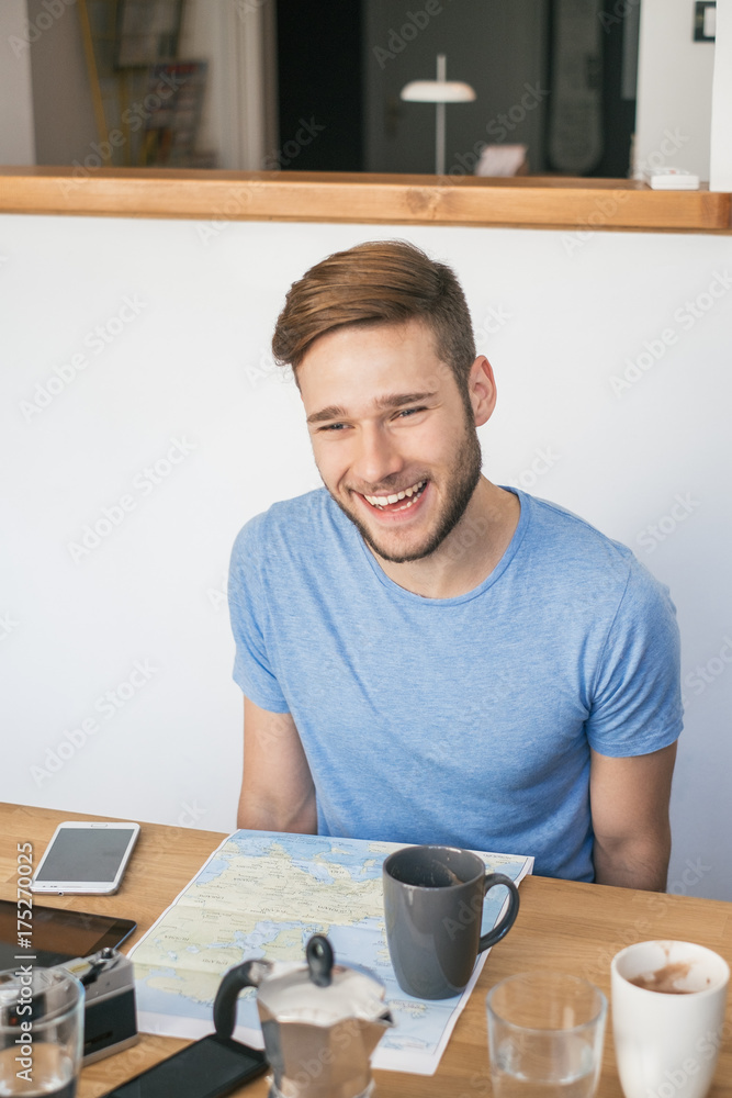 Young Smiling Man Planning a Trip Young Smiling Man Planning a Trip