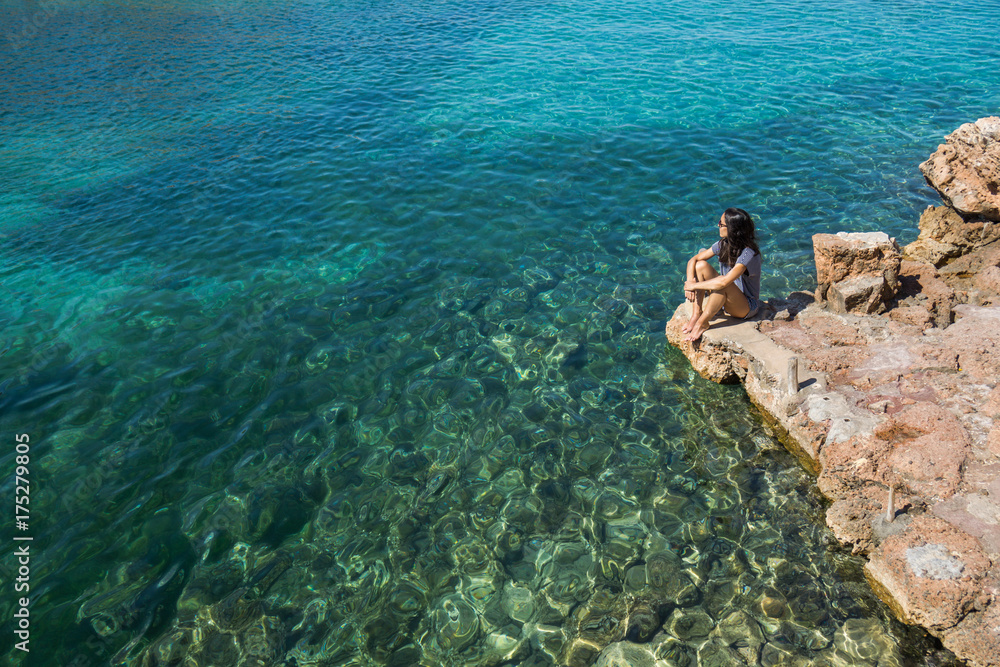 Woman in a beach with crystalline water Woman in a beach with crystalline water