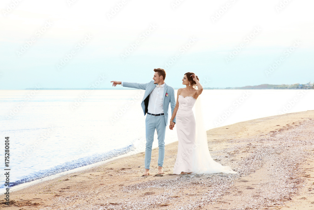 Happy wedding couple walking on beach Happy wedding couple walking on beach