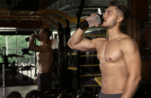 Sporty young man drinking w...