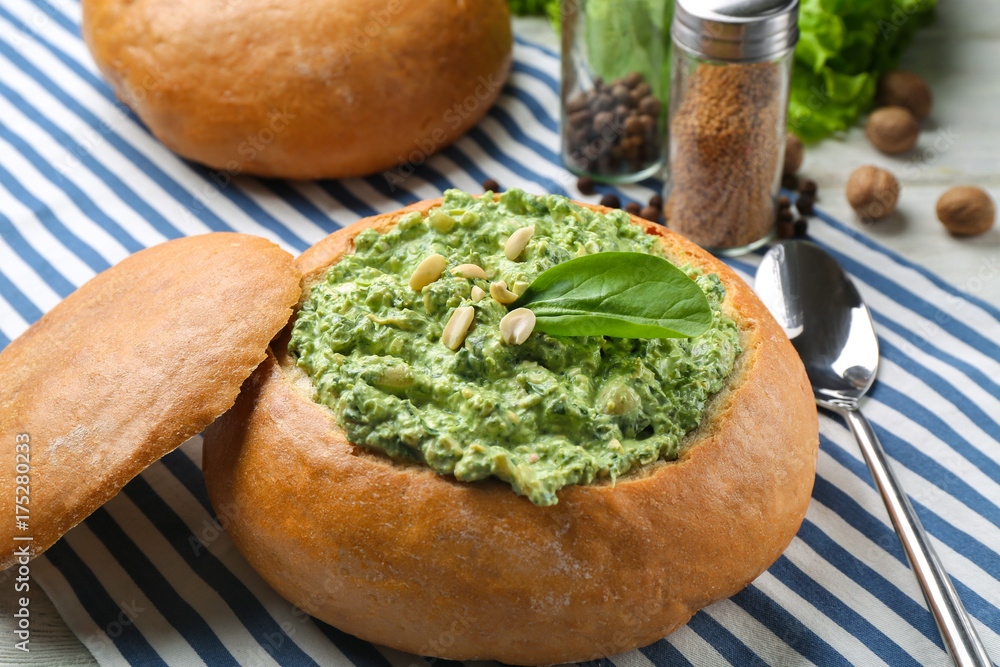 Bread loaf filled with tasty spinach sauce on table Bread loaf filled with tasty spinach sauce on table