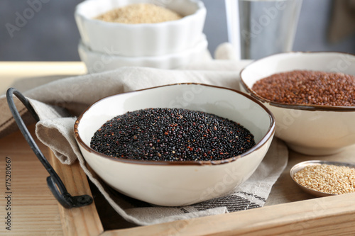 Bowl with quinoa seeds on wooden tray