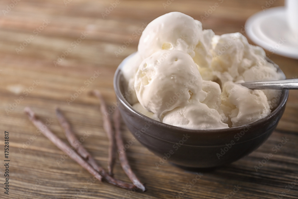 Bowl with yummy vanilla ice cream balls on wooden table Bowl with yummy vanilla ice cream balls on wooden table