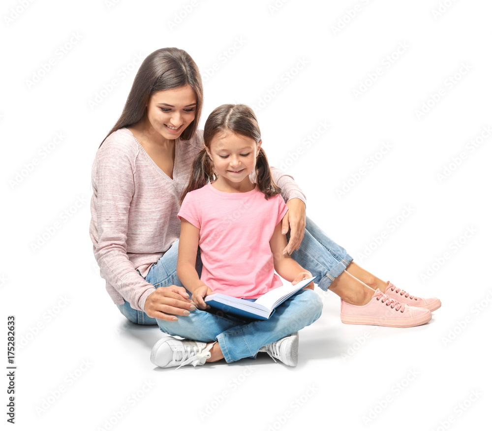 Young woman and her little daughter reading book on white background Young woman and her little daughter reading book on white background