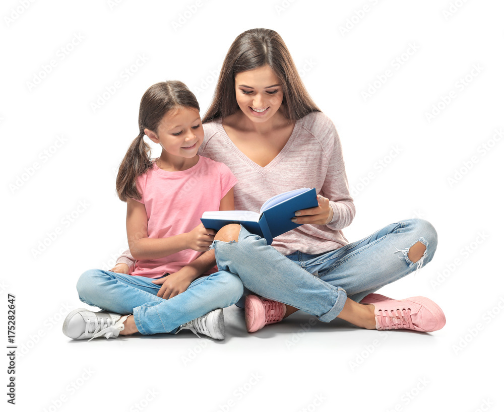 Young woman and her little daughter reading book on white background Young woman and her little daughter reading book on white background