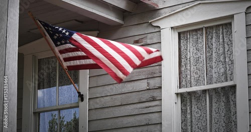 American Flag Waves On Farm House Porch