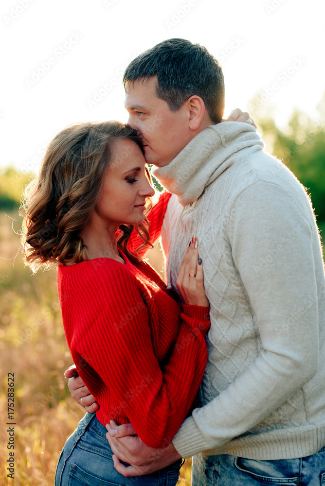 young loving couple hugging at sunset in autumn at an outdoor park young loving couple hugging at sunset in autumn at an outdoor park