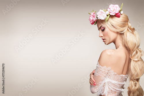 Beautiful woman portrait with long blonde hair and flowers on head. Tender bride. 
