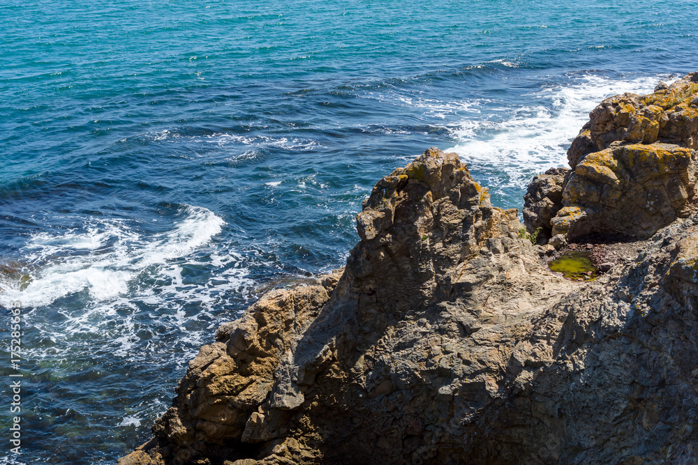 Blue sea, waves and rocky shore.