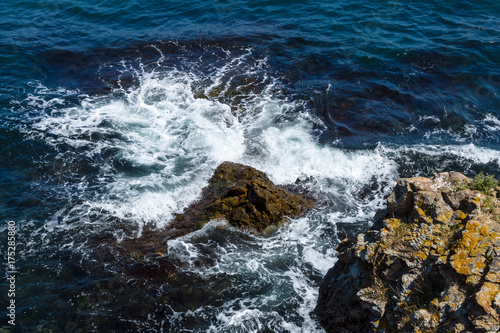 Blue sea, waves and rocky shore.