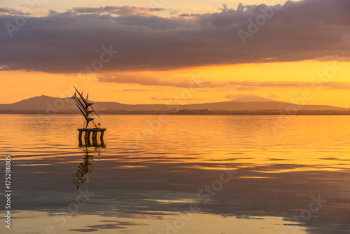 Sculpture on a lake at sunset.