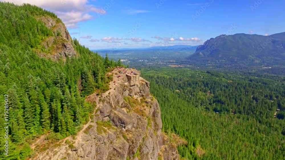 Breathtaking aerial of high cliff in mountain hills with a blue lake in the background Breathtaking aerial of high cliff in mountain hills with a blue lake in the background